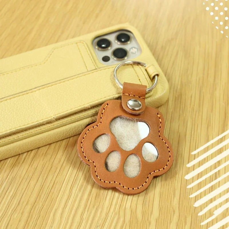 Llavero portátil multifuncional con diseño de huella de gato, fabricado en cuero, con compartimento para guardar pelo o recuerdos de mascotas.