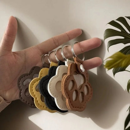Llavero portátil multifuncional con diseño de huella de gato, fabricado en cuero, con compartimento para guardar pelo o recuerdos de mascotas.