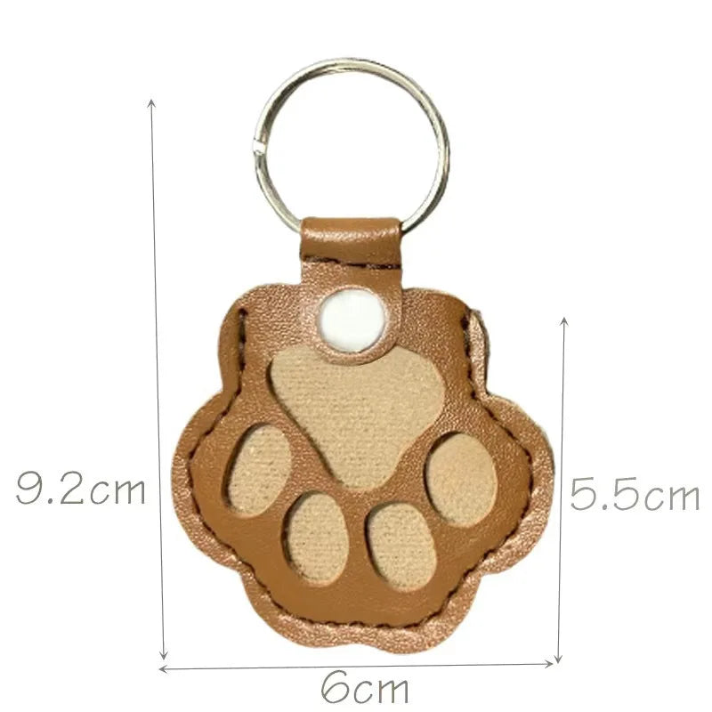 Llavero portátil multifuncional con diseño de huella de gato, fabricado en cuero, con compartimento para guardar pelo o recuerdos de mascotas.