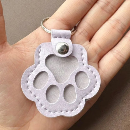 Llavero portátil multifuncional con diseño de huella de gato, fabricado en cuero, con compartimento para guardar pelo o recuerdos de mascotas.
