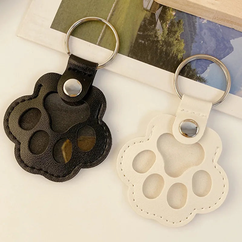 Llavero portátil multifuncional con diseño de huella de gato, fabricado en cuero, con compartimento para guardar pelo o recuerdos de mascotas.