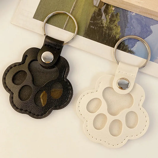 Llavero portátil multifuncional con diseño de huella de gato, fabricado en cuero, con compartimento para guardar pelo o recuerdos de mascotas.